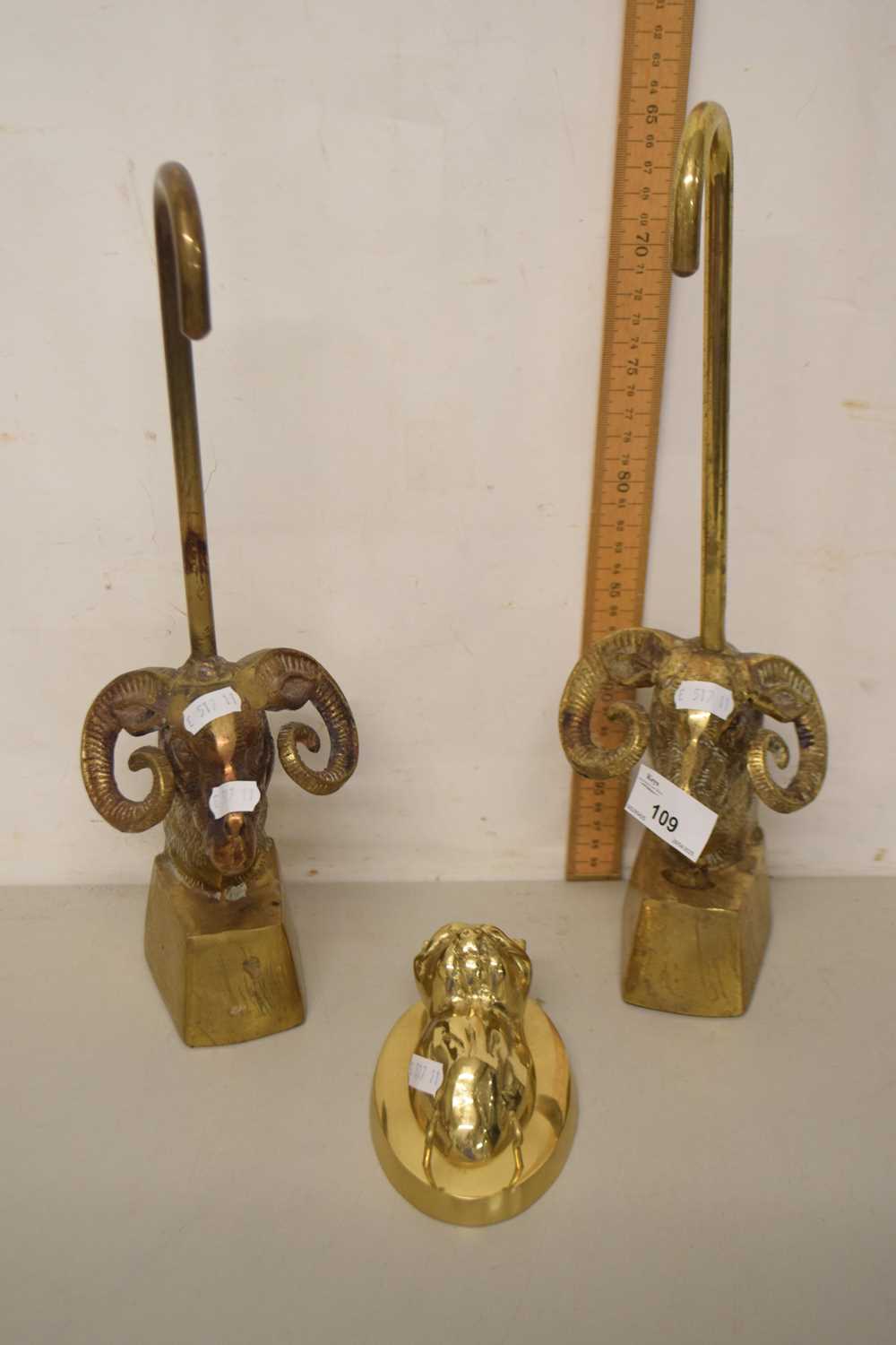 Lot 109 - A pair of brass door stops formed as rams...