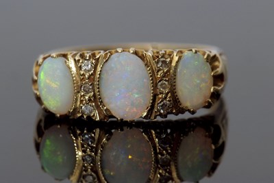 Lot 303 - Three stone opal and diamond ring featuring...