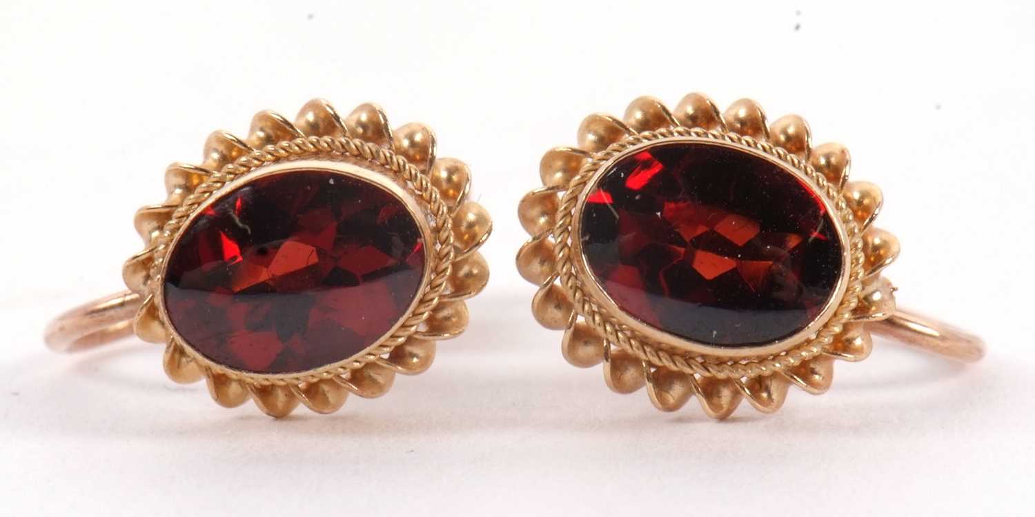 Lot 95 - A pair of garnet earrings, the oval collet...