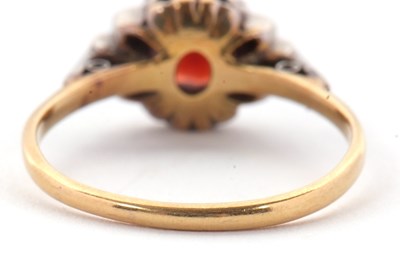 Lot 21 - A garnet and diamond ring, the central round...