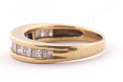 Lot 24 - A diamond ring, the channel set graduated...
