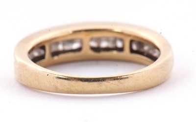 Lot 24 - A diamond ring, the channel set graduated...