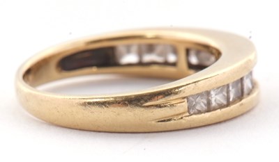 Lot 24 - A diamond ring, the channel set graduated...