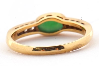 Lot 30 - A jade and diamond ring, the oval collet...