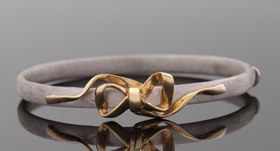 Lot 290 - A gold bangle, the hinged textured white gold...