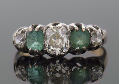 Lot 275 - An emerald and diamond ring, set with two...