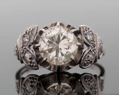 Lot 264 - A diamond ring, the central round brilliant...