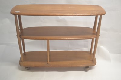 Lot 477 - An Ercol light elm three tier shelf unit on...