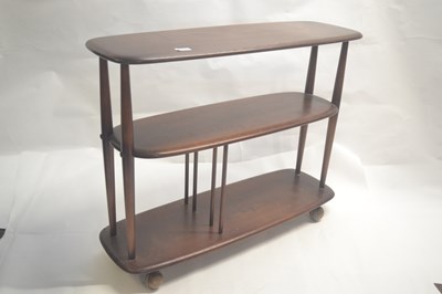 Lot 478 - An Ercol dark elm three tier shelf unit on...