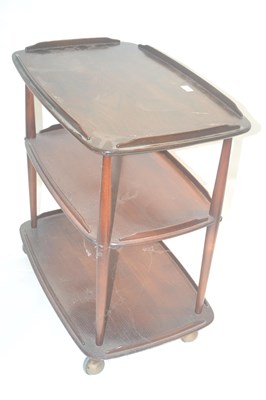 Lot 604 - An Ercol dark elm three tier tea trolley on...