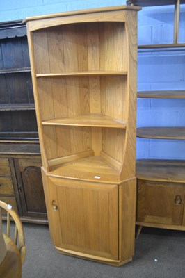 Lot 493 - An Ercol light elm corner cabinet with open...