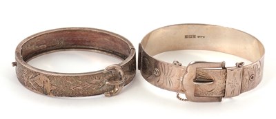 Lot 255 - Two silver bangles: a buckle bangle, 15mm wide,...