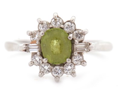 Lot 67 - A peridot and diamond ring, the central round...