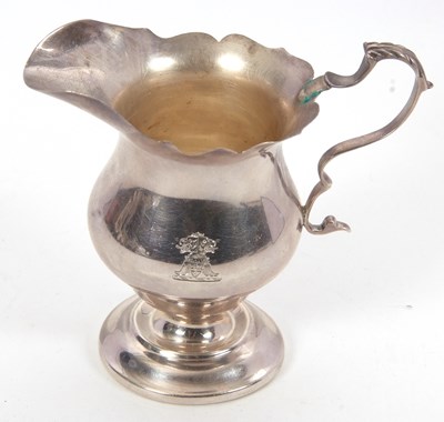 Lot 103 - A George V silver cream jug helmet shaped with...