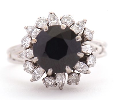 Lot 62 - A sapphire and diamond ring, the central round...