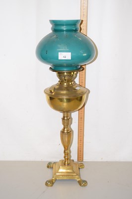 Lot 42 - Brass oil lamp with four footed base
