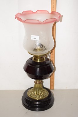 Lot 69 - An oil lamp with frilled shade and black font