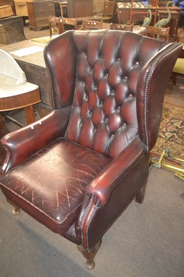 Lot 493 - A red leather Chesterfield style wing back...