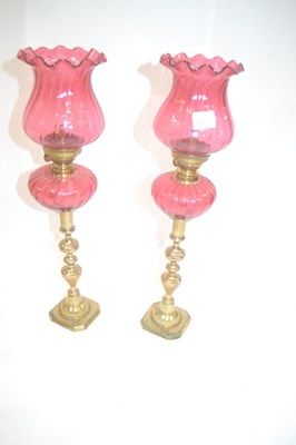 Lot 575 - A pair of small cranberry oil lamps, the bases...
