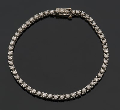 Lot 285 - An 18ct diamond line bracelet, set throughout...