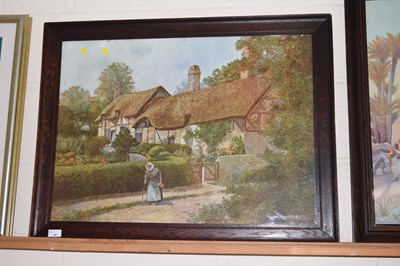 Lot 35 - A framed print of a figure before a thatched...