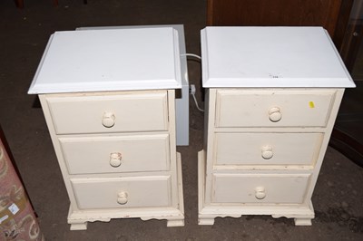 Lot 779 - A pair of three drawer cream painted bedside...