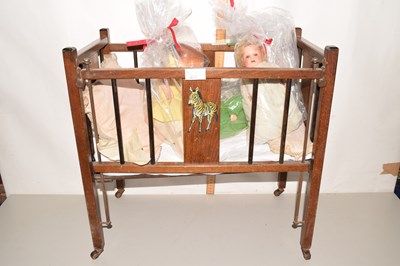 Lot 576 - Three dolls in hand painted wooden crib