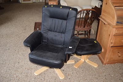 Lot 314 - A black swivel armchair and matching footstool
