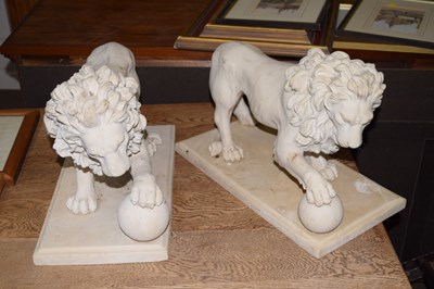 Lot 748 - Two resin models of lions with foot on ball on...