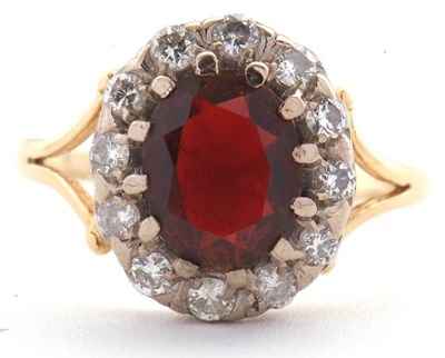 Lot 24 - A garnet and diamond cluster ring, set with an...