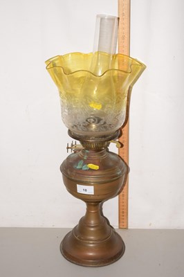 Lot 18 - A brass based oil lamp with yellow shade