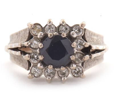 Lot 14 - An 18ct sapphire and diamond ring, the central...