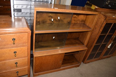 Lot 694 - 20th Century oak bookcase with sliding glass...