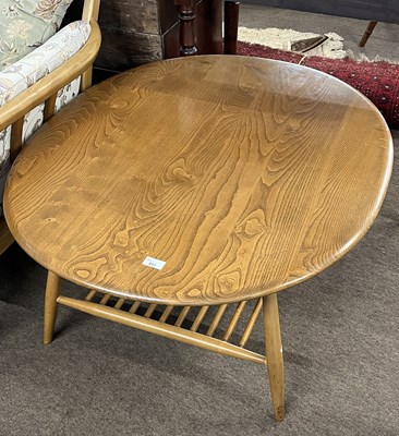 Lot 412 - An Ercol light elm oval coffee table with base...