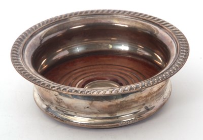 Lot 83 - An Elizabeth II silver bottle coaster, applied...