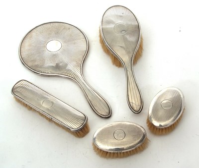 Lot 119 - A George V silver backed three piece dressing...
