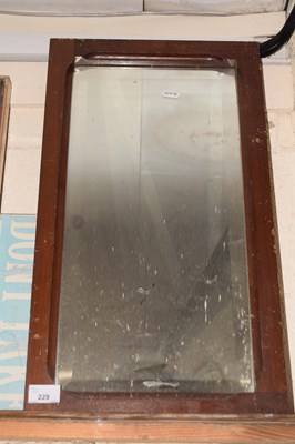 Lot 229 - A bevelled wall mirror