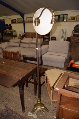 Lot 368 - An antique brass floor lamp on a three footed...