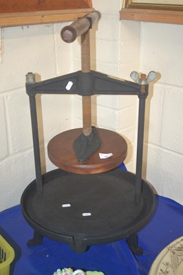 Lot 17 - A metal cheese press with wooden handle