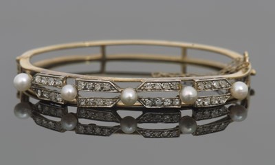 Lot 282 - A pearl and diamond bangle, the upper half set...