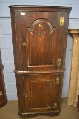 Lot 402 - A George III oak floor standing corner cabinet...