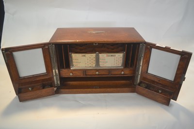 Lot 316 - An oak two drawer letter rack with calendar...