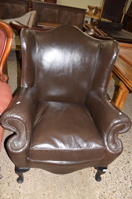 Lot 295 - A dark brown leather wing chair on cabriole...