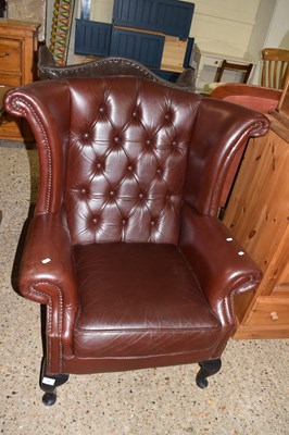 Lot 297 - Dark brown buttoned leather wing chair on...