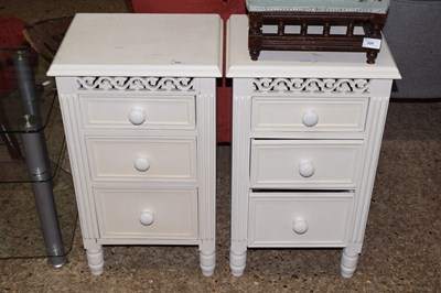 Lot 323 - A pair of white painted three drawer bedside...