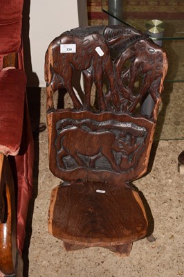 Lot 334 - A carved African low chair