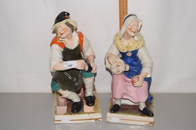 Lot 147 - A pair of Staffordshire figures seated on...