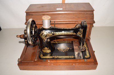 Lot 125 - A vintage wooden cased sewing machine
