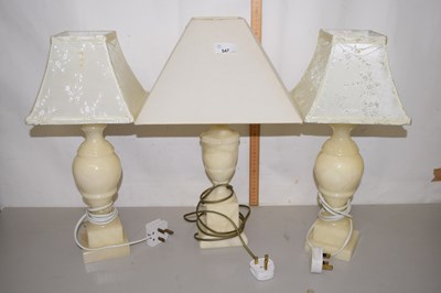 Lot 547 - Three onyx lamp stands with white shades