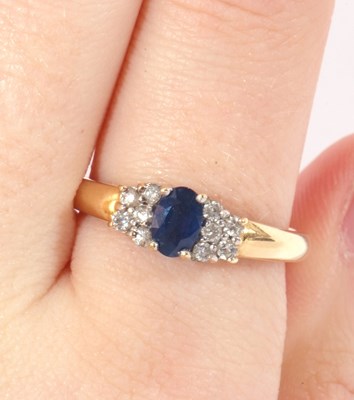 Lot 44 - Sapphire and diamond ring centring an oval...